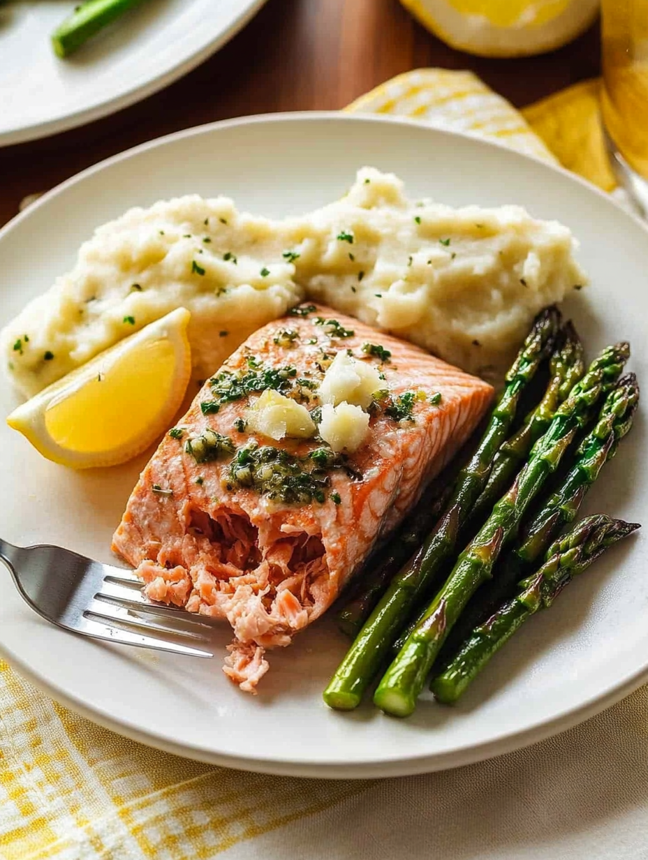 A plate of food with salmon, potatoes, and asparagus.