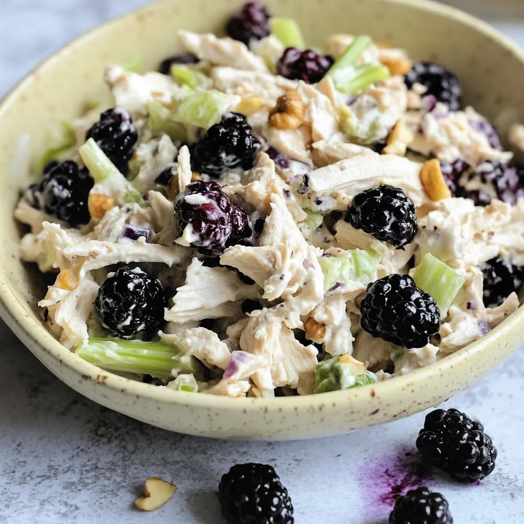 A bowl of chicken salad with blackberries.