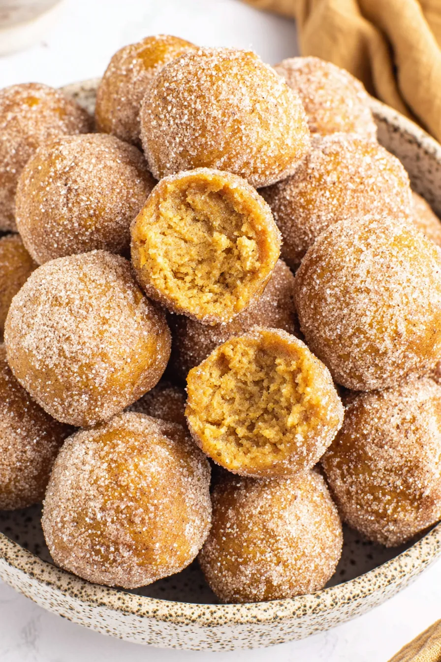A bowl of sugar coated donuts.