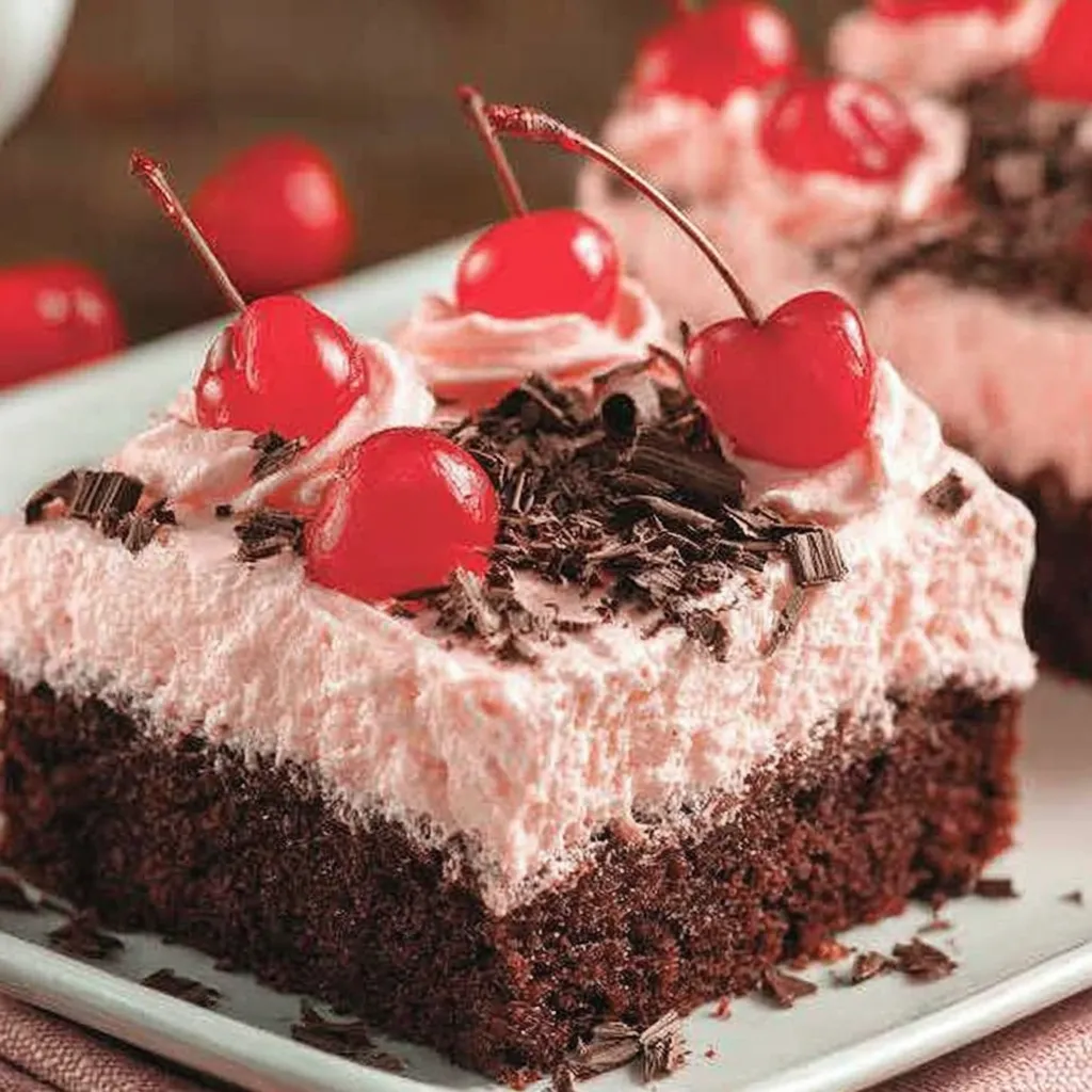 A slice of chocolate cake with cherries on top.