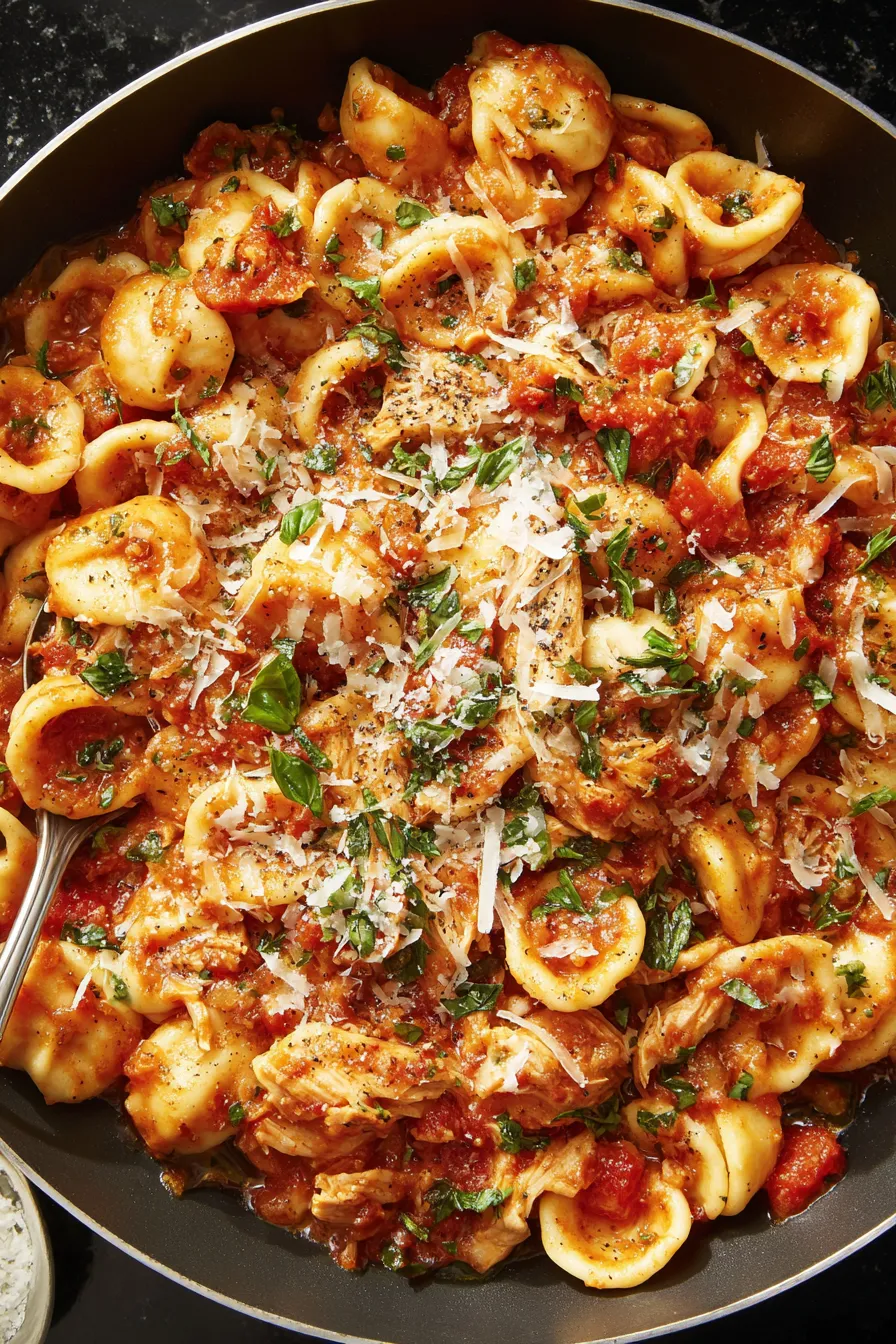 A bowl of pasta with chicken and cheese.