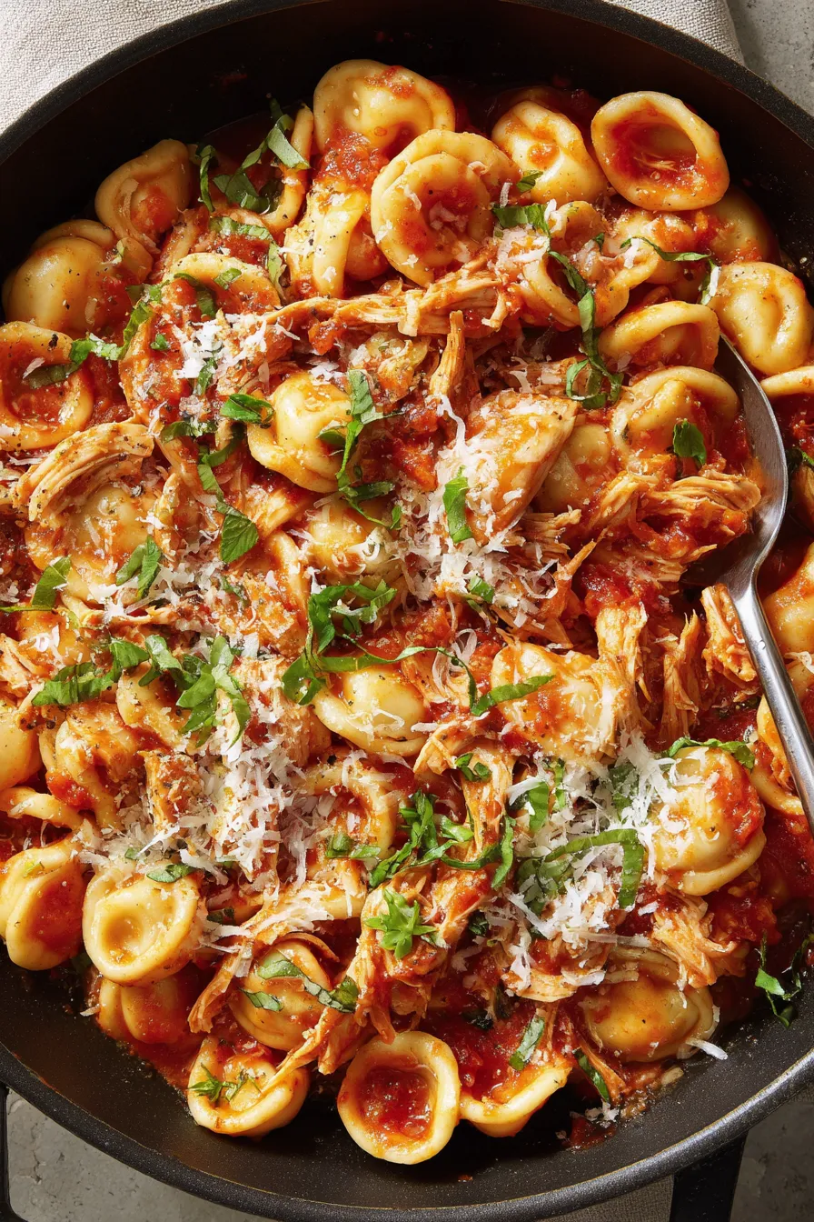 A bowl of pasta with chicken and cheese.